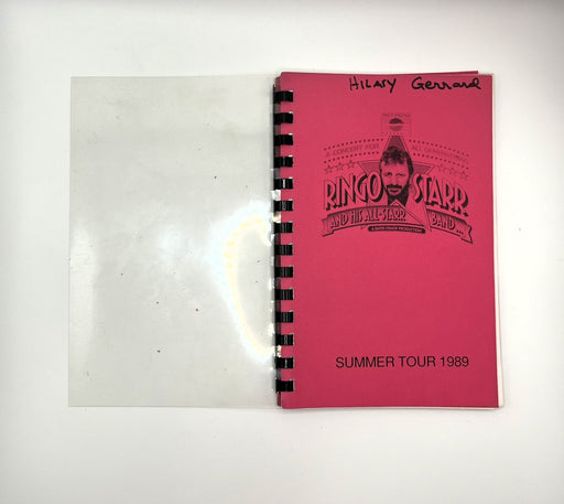 A vintage spiral-bound booklet or program cover for Ringo Starr and the All Star Band summer tour 1969, shown open on a white background. The right page is bright pink with black printed text and a portrait graphic, while the left page is blank white paper.