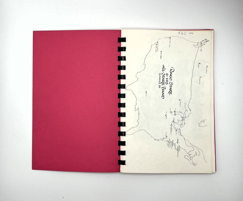 An open spiral-bound tour programme for Ringo Starr's All Starr Band on a white background, showing a solid magenta-pink left page and an off-white right page with a hand-drawn map and handwritten text.